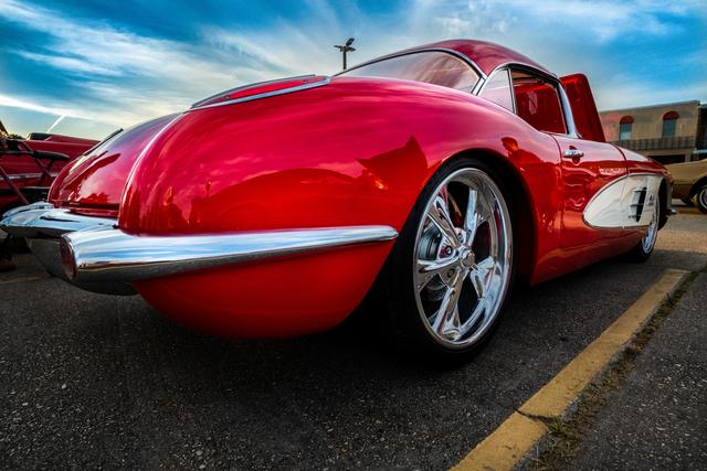 Low-angle rear view of a red C1 Corvette with chrome bumpers at a car show