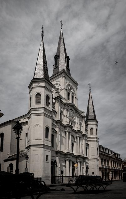 Black and white St. Louis Cathedral spires under a brooding sky